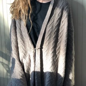 an open comfy brown cardigan with a custom pin